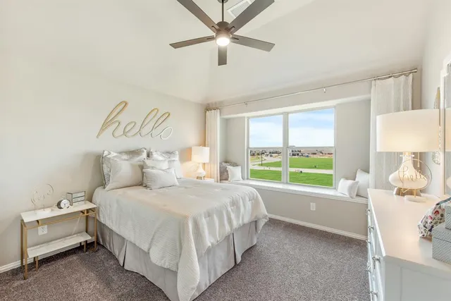 a bedroom with a bed and a large window