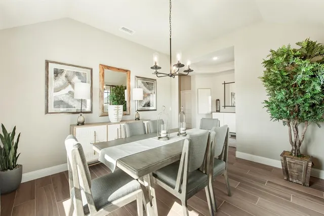 a dining room with furniture potted plants and wooden floor