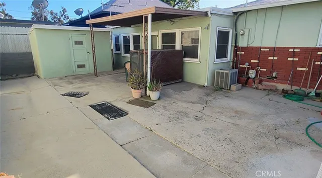 a backyard of a house with barbeque oven and outdoor seating