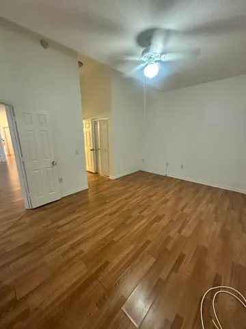 a view of empty room with wooden floor