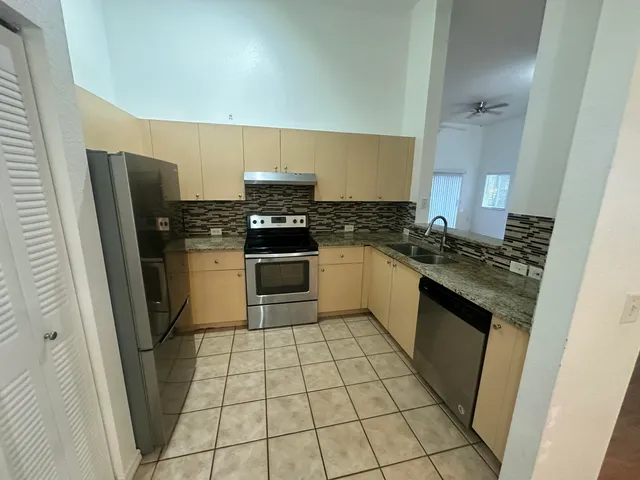 a kitchen with granite countertop a stove sink and cabinets