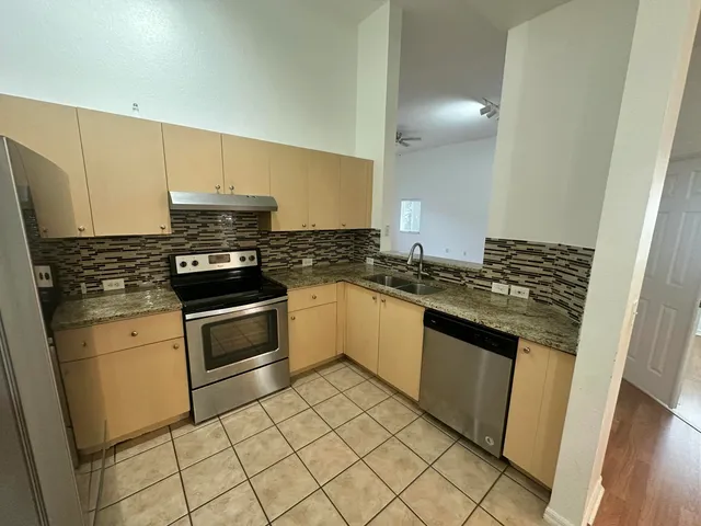 a kitchen with granite countertop a stove and a sink