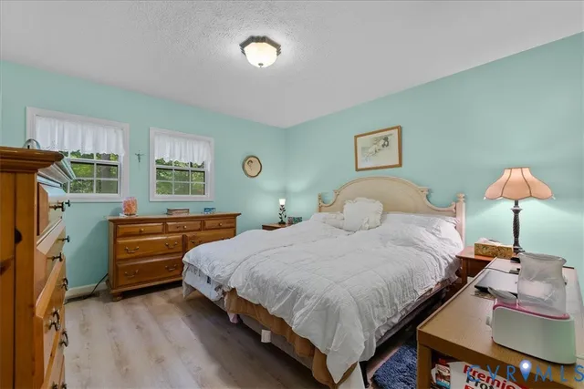 a bedroom with bed and wooden floor