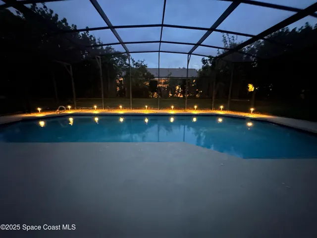 a view of a swimming pool with a yard in front of it