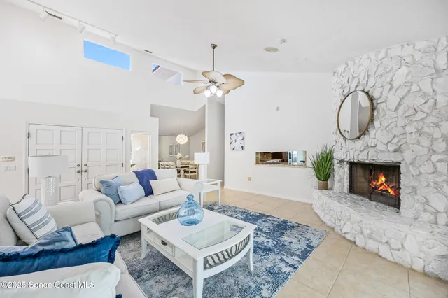 a living room with furniture a fireplace and a chandelier