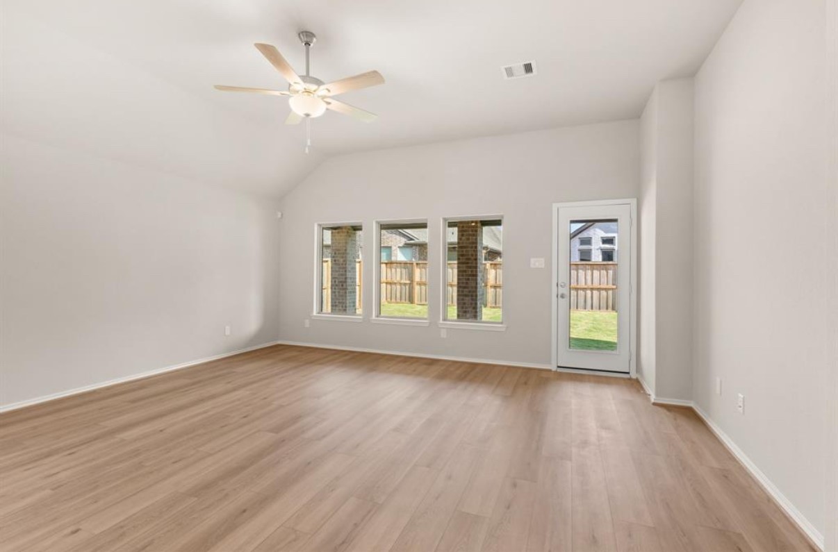 13814 San Pasqual Pointe Drive Cypress, TX 77433 - Photo 8 of 24 an empty room with wooden floor chandelier fan and windows