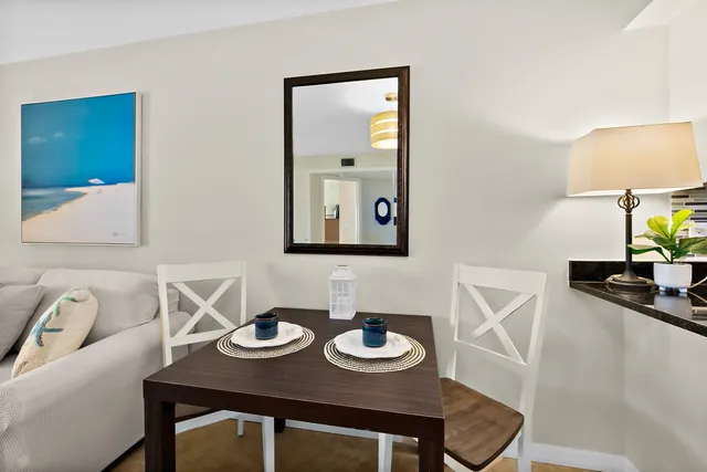 a living room with furniture kitchen view and a chandelier