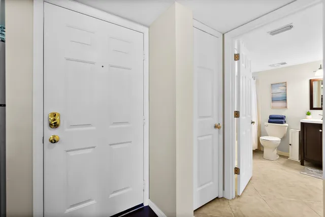 a view of a patio with table and chairs under an umbrella with a barbeque