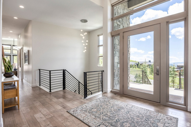 140 West Vista Road Kamas, UT 84036 - Photo 53 of 101 Entry with wood-finish flooring, a modern chandelier, and a metal horizontal bar railing