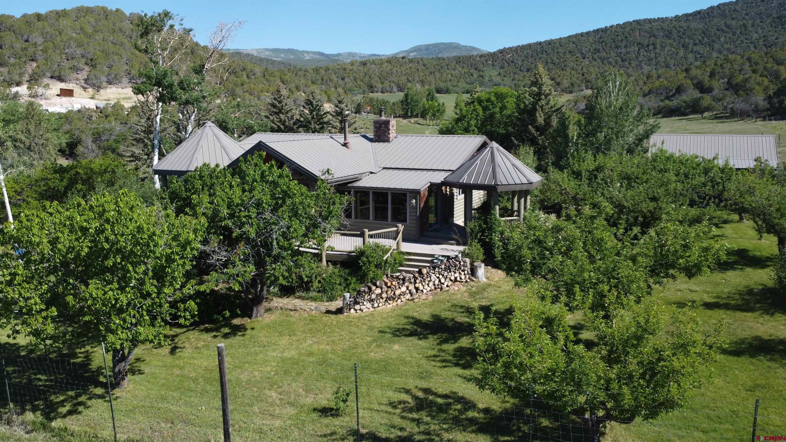 24119 Ute Trail Road Cedaredge, CO 81413 - Photo 23 of 26 a view of a house with a yard and sitting area