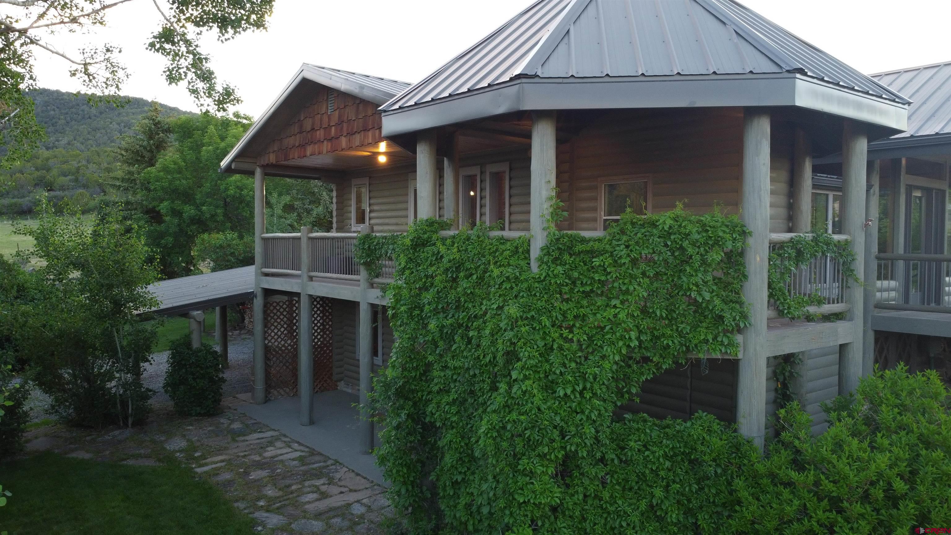 24119 Ute Trail Road Cedaredge, CO 81413 - Photo 3 of 26 a front view of a house with a yard and trees