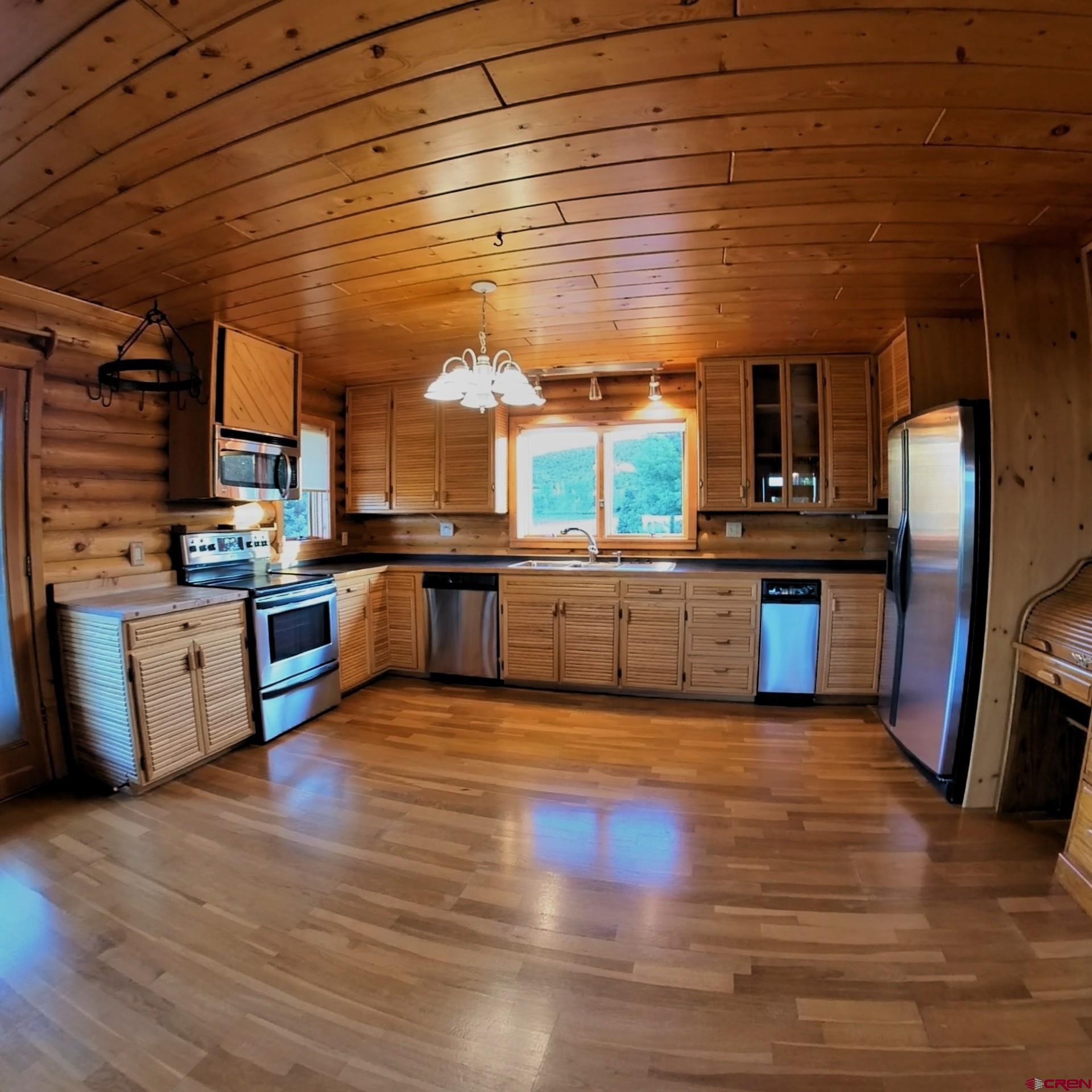24119 Ute Trail Road Cedaredge, CO 81413 - Photo 9 of 26 a large kitchen with stainless steel appliances granite countertop wooden floors and a sink