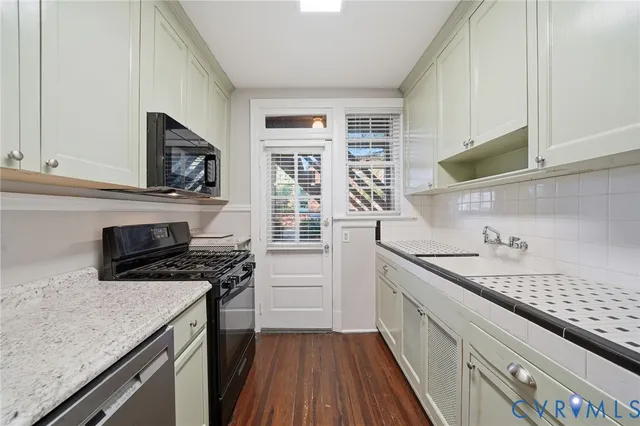 a kitchen with a sink stove top oven and cabinets