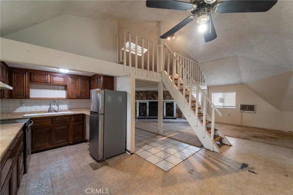 33041 Briggs Road Menifee, CA 92584 - Photo 23 of 60 a kitchen with stainless steel appliances granite countertop a refrigerator a sink dishwasher a stove and a dining table with wooden floor