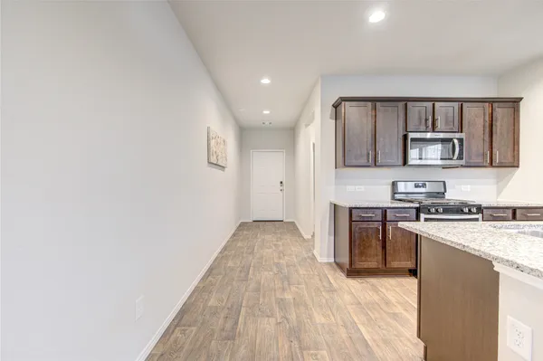 a view of a kitchen with a sink and dishwasher a refrigerator with wooden floor