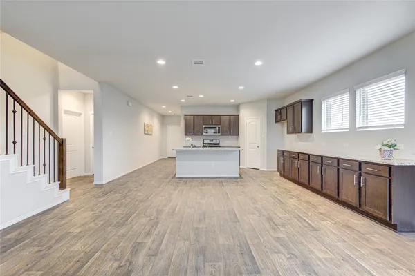 a view of a kitchen with wooden floor and electronic appliances