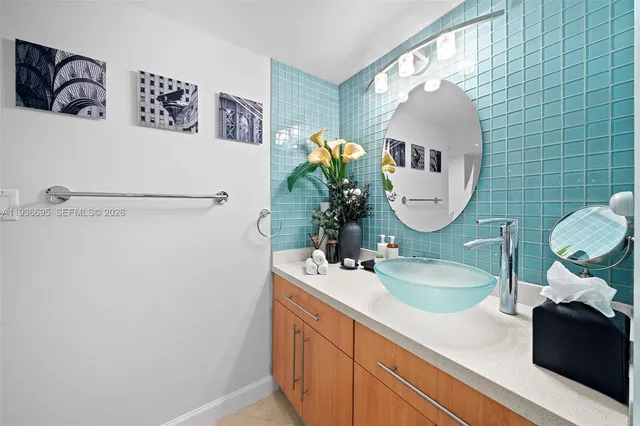 a bathroom with a sink a faucet a potted plant and a mirror