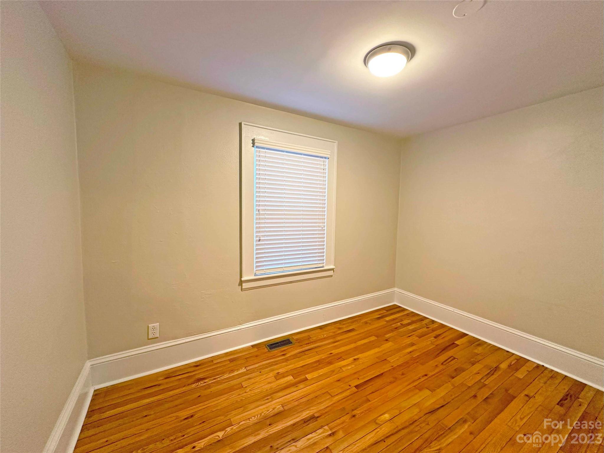 Undisclosed Address Hickory, NC 28601 - Photo 19 of 19 a view of an empty room with wooden floor and a window