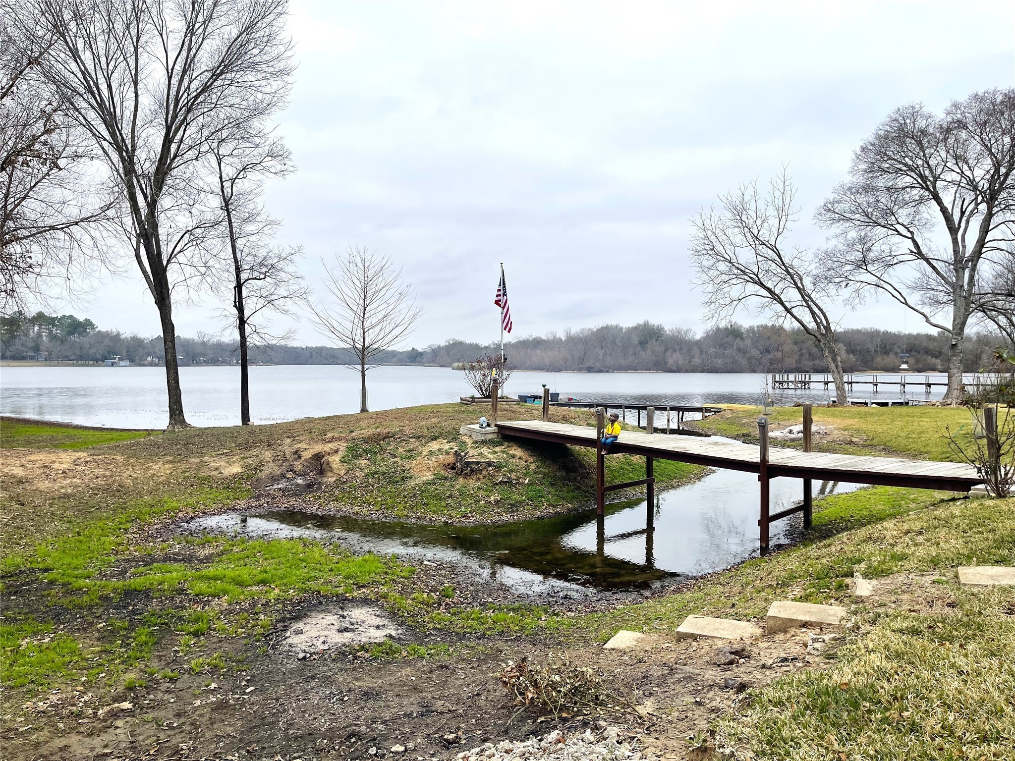 351 Clb Lk Road Teague, TX 75860 - Photo 33 of 33 a view of a lake with a bench and trees around