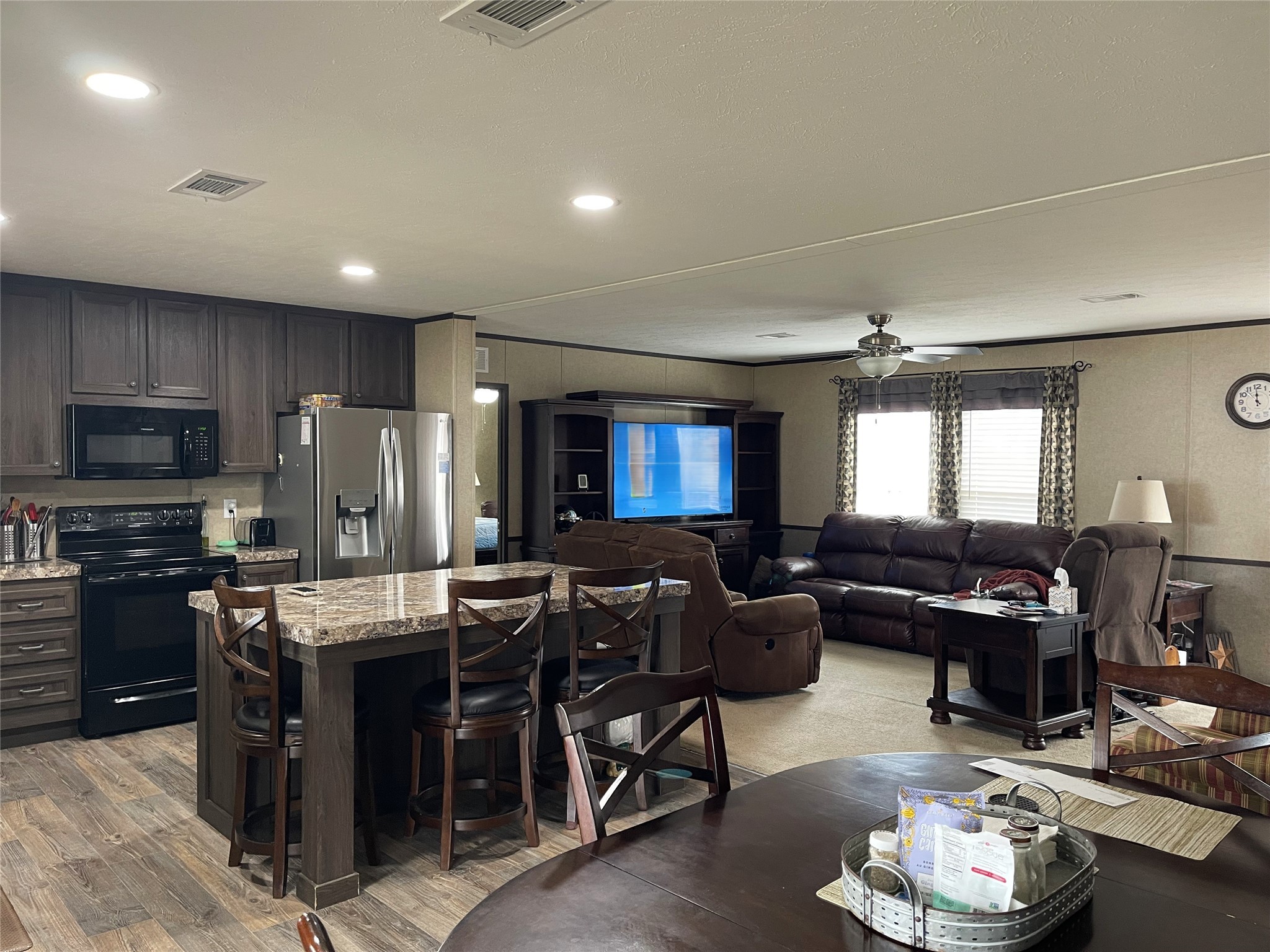351 Clb Lk Road Teague, TX 75860 - Photo 8 of 33 a kitchen with stainless steel appliances kitchen island granite countertop a refrigerator a stove a sink a dining table and chairs with wooden floor