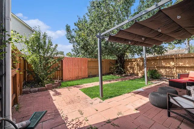 a view of a backyard with table and chairs under an umbrella