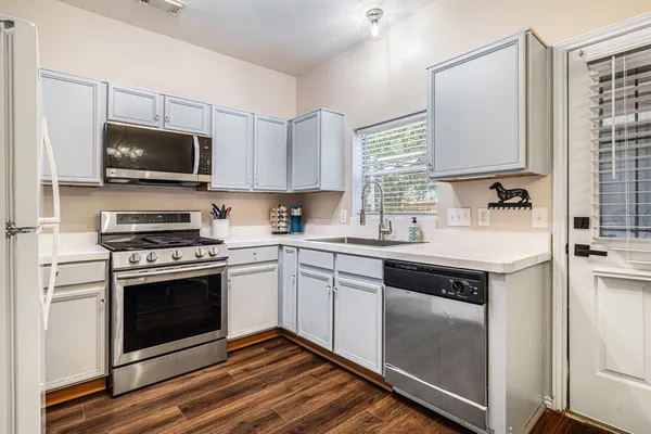 a kitchen with cabinets stainless steel appliances and a sink