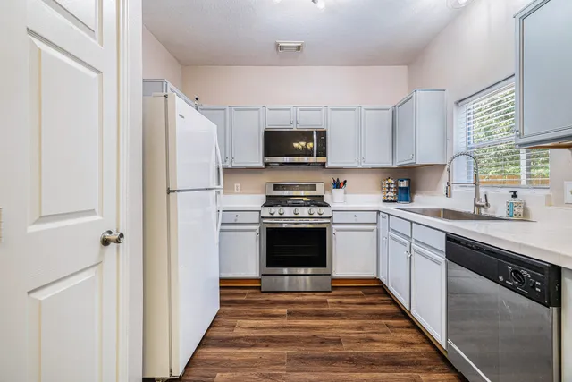 a kitchen with granite countertop a refrigerator and a stove