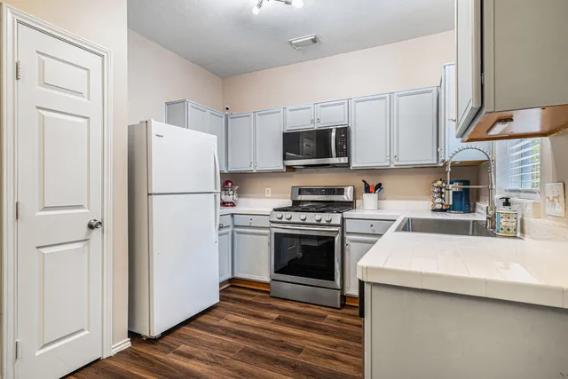 a kitchen with a refrigerator a stove top oven a sink and dishwasher
