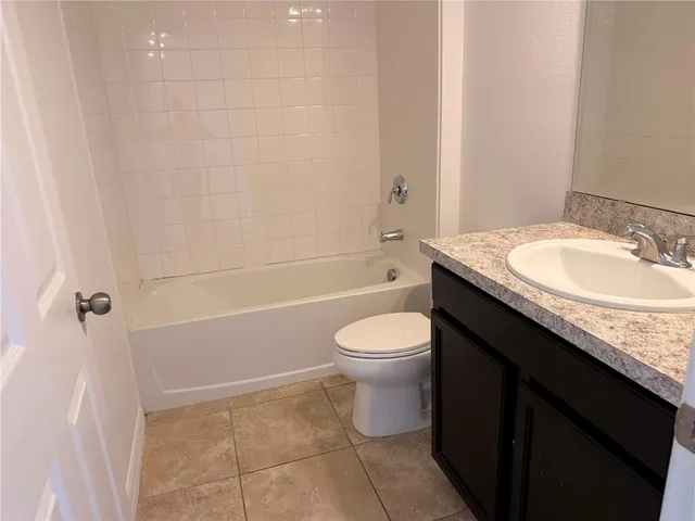 a bathroom with a granite countertop sink a toilet and bathtub