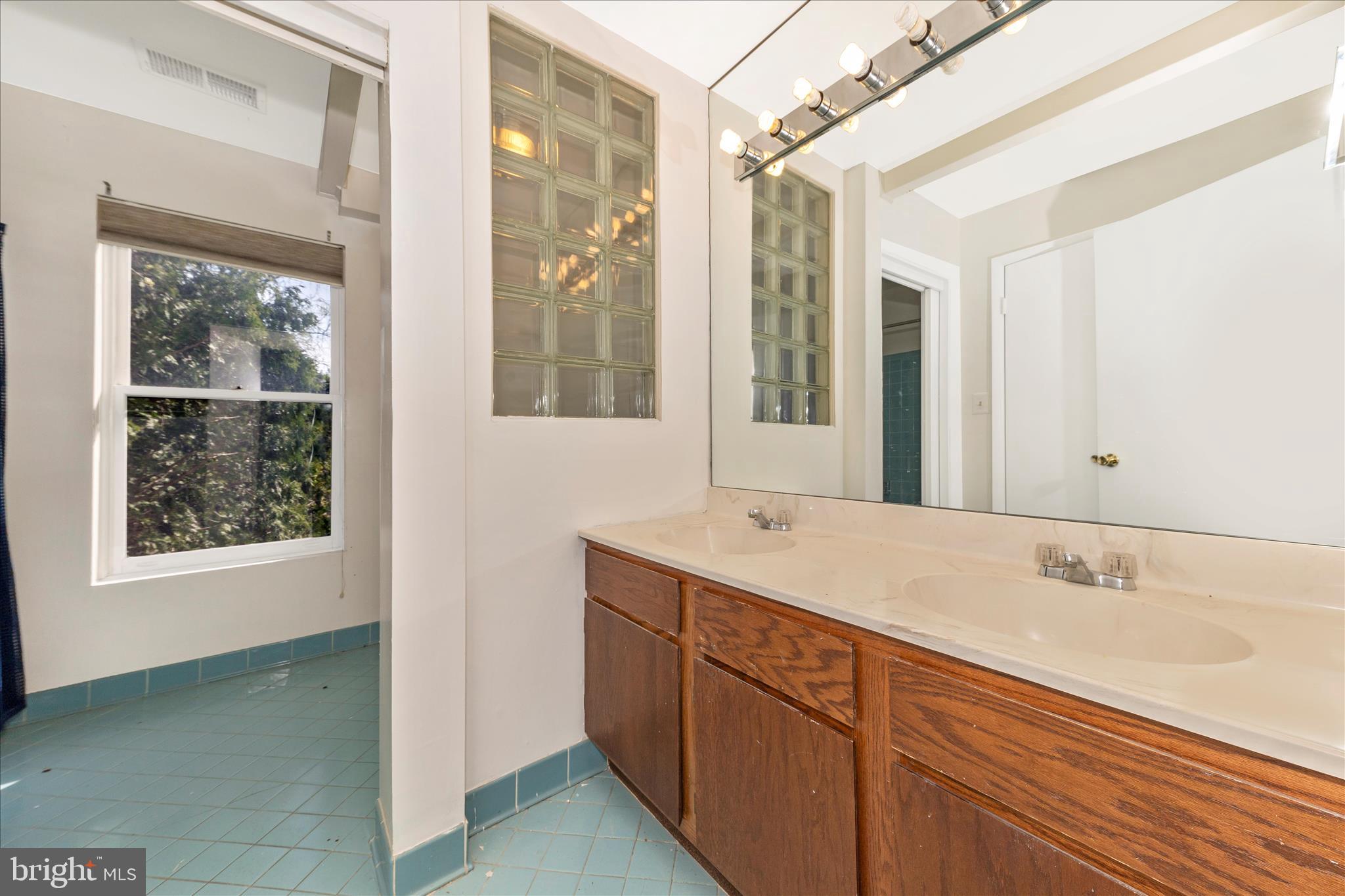 9309 Old Georgetown Road Bethesda, MD 20814 - Photo 21 of 50 a bathroom with a shower sink and mirror