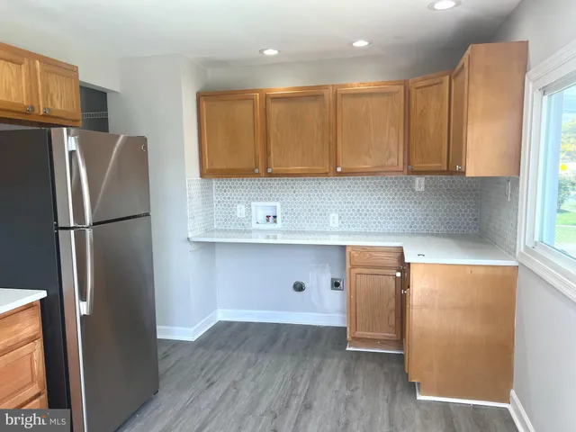 a kitchen with a refrigerator a stove top oven a sink and a center island