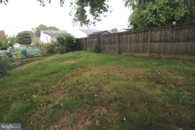 a view of a backyard with potted plants and wooden fence