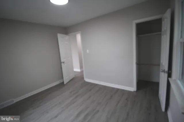 an empty room with wooden floor and closet