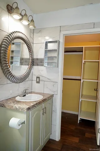 a bathroom with a granite countertop sink a mirror and vanity