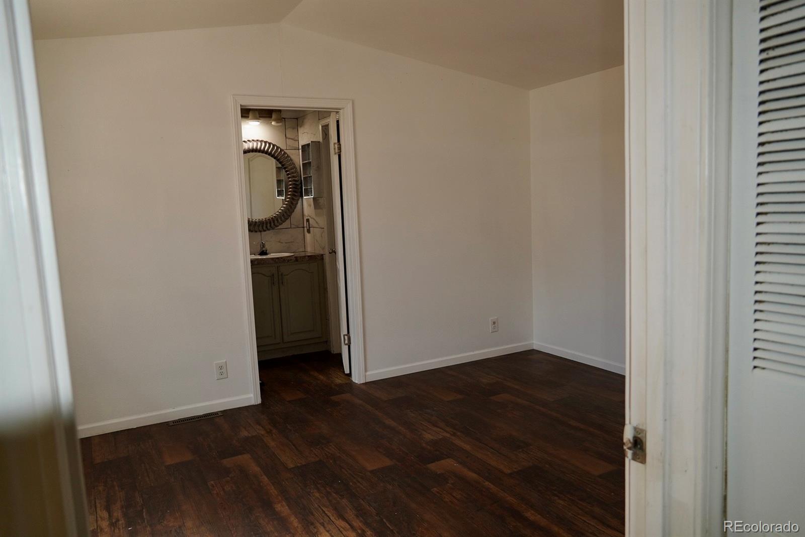 9100 Tejon Street Denver, CO 80260 - Photo 9 of 23 an empty room with wooden floor mirror and closet