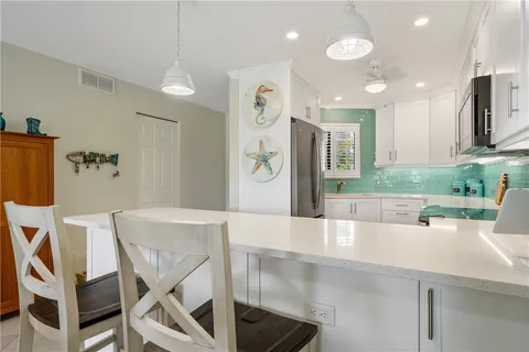 a view of a dining room with furniture and a kitchen view