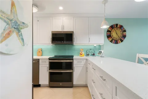 a kitchen with stainless steel appliances white cabinets and a stove top oven