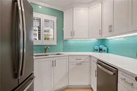 a kitchen with white cabinets and a refrigerator