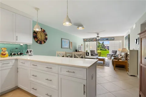 a kitchen with a sink dishwasher and white cabinets with wooden floor