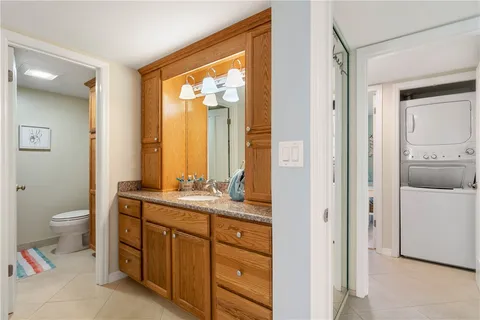 a bathroom with a granite countertop toilet a sink and a mirror