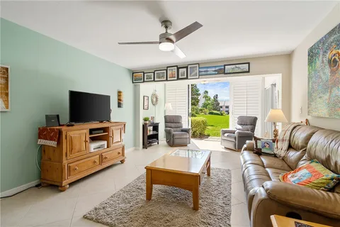 a living room with furniture a flat screen tv and a large window