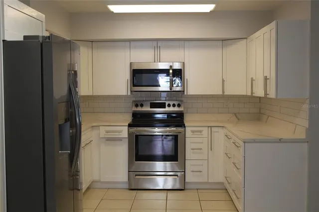 a kitchen with cabinets stainless steel appliances and a sink