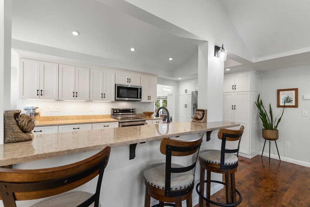 4 Senator Road Woburn, MA 01801 - Photo 7 of 36 a kitchen with a dining table chairs refrigerator and microwave