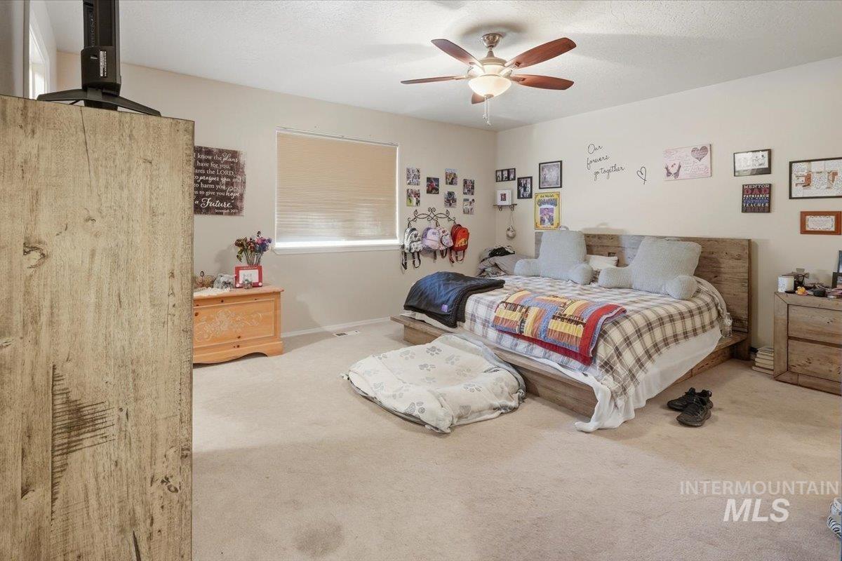 2714 Colfax Drive Caldwell, ID 83607 - Photo 16 of 40 Carpeted bedroom featuring a ceiling fan with light fixture, a window with blinds, and light-toned walls