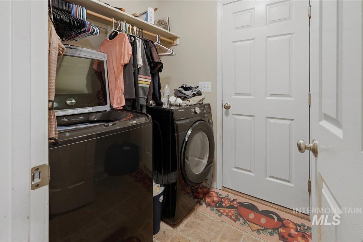 2714 Colfax Drive Caldwell, ID 83607 - Photo 18 of 40 Laundry area featuring a built-in shelving unit, clothes hanging rod, and tiled flooring