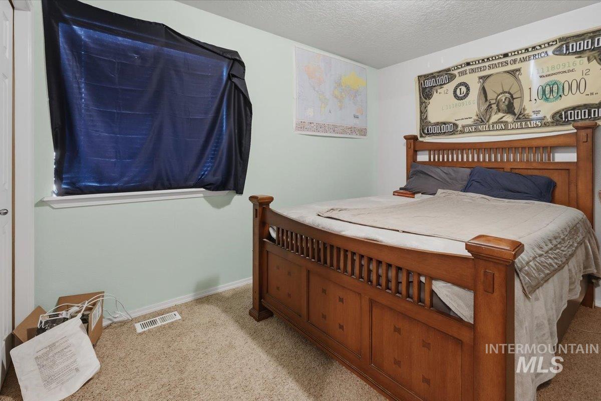 2714 Colfax Drive Caldwell, ID 83607 - Photo 22 of 40 Carpeted room featuring a window with blinds, light green wall paint, and white trim