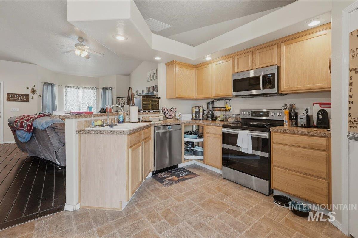 2714 Colfax Drive Caldwell, ID 83607 - Photo 7 of 40 Kitchen featuring wood-finish cabinetry, stainless steel appliances, and a double basin sink with a mounted faucet
