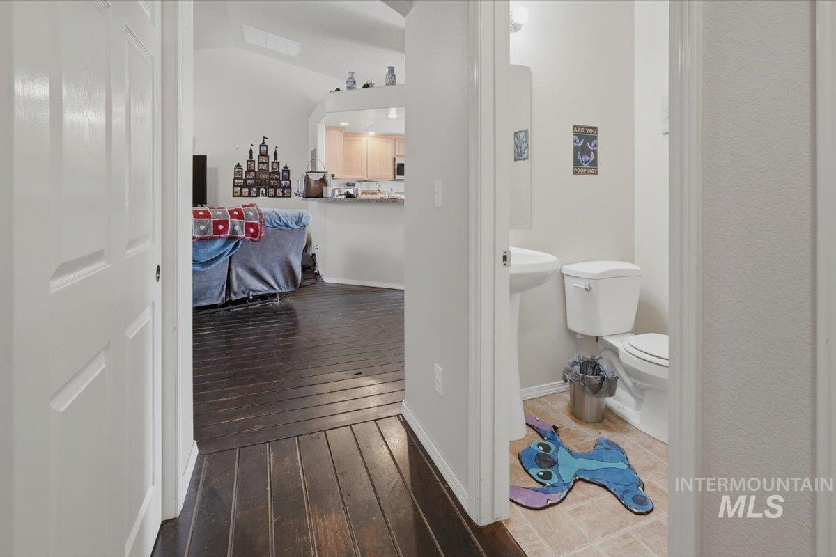 2714 Colfax Drive Caldwell, ID 83607 - Photo 9 of 40 Hallway featuring dark wood-finish flooring, leading to a living area with vaulted ceilings