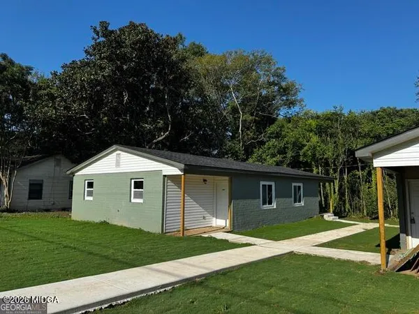a front view of a house with a garden and yard
