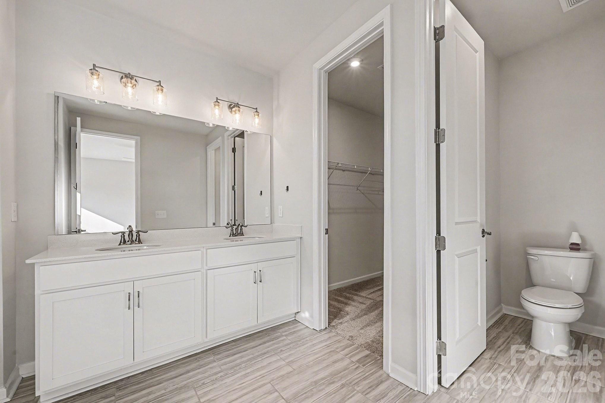 5451 Comiskey Alley Kannapolis, NC 28081 - Photo 19 of 27 a spacious bathroom with a toilet a sink and a mirror